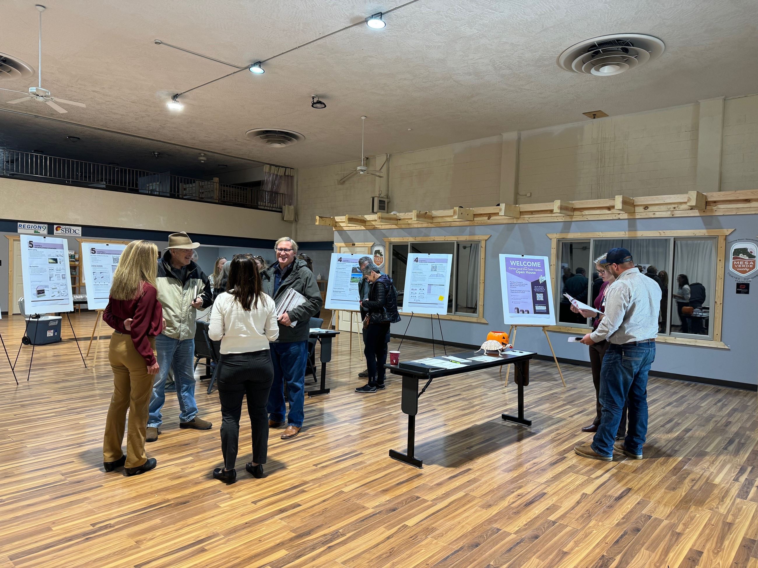 An picture of a group of people and posters discussing the Cortez Land Use Code Update.